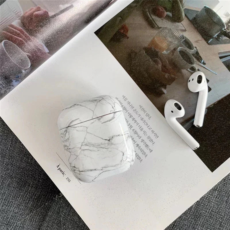 Marble pattern AirPods case with wireless earbuds on an open magazine