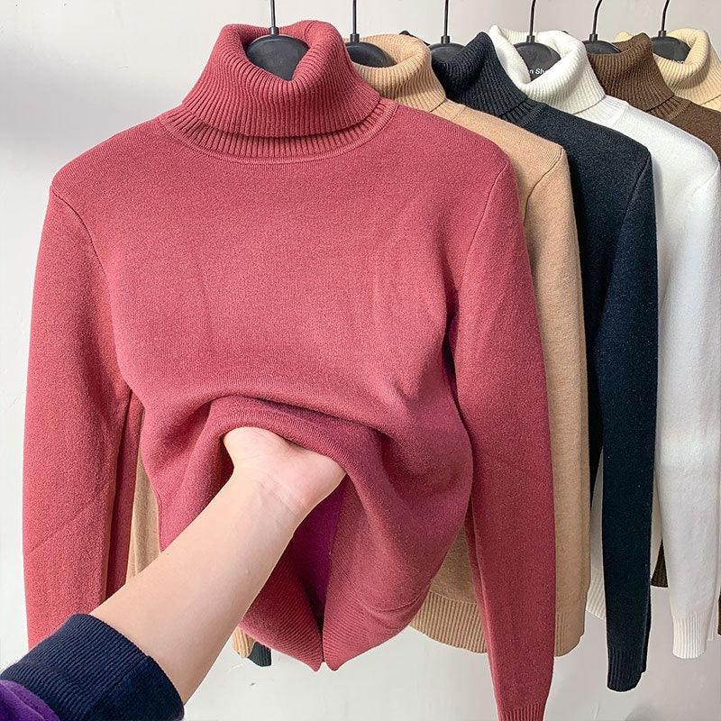 Soft knit turtleneck sweaters in multiple colors on hangers, hand showing stretch fabric