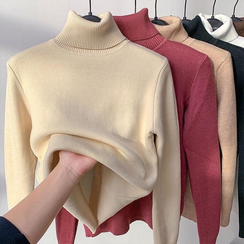 Assorted knit turtleneck sweaters in neutral and pink tones hanging on black hangers