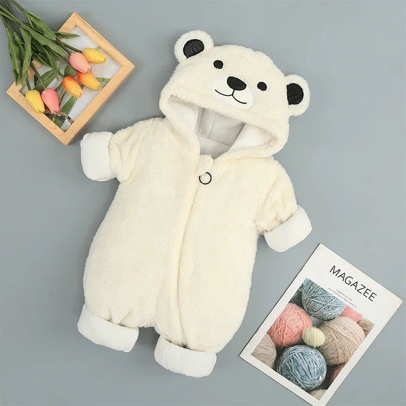 Cream fleece baby bear onesie with hood, surrounded by tulips and yarn magazine